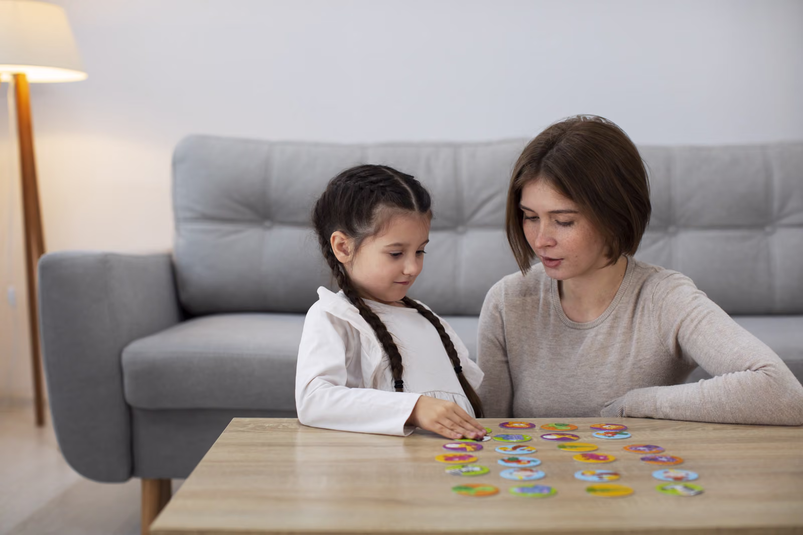 A parent and child playing a game together on a coffee table at home
